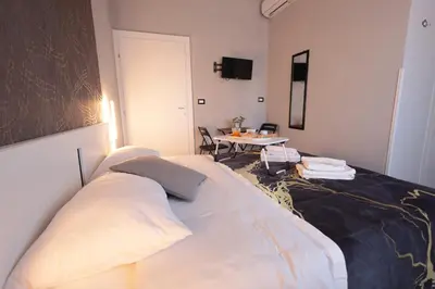 Letto o letti in una camera di A cartulina e Napulè Attico con Vista Porto Ascensore Colazione Inclusa Struttura nel cuore autentico di Napoli a 5 minuti dalla Stazione Centrale e dal Centro Storico AC