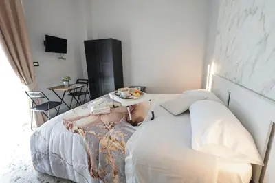 Letto o letti in una camera di A cartulina e Napulè Attico con Vista Porto Ascensore Colazione Inclusa Struttura nel cuore autentico di Napoli a 5 minuti dalla Stazione Centrale e dal Centro Storico AC